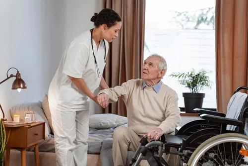 Nurse caring for an elderly man in a wheelchair at home